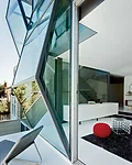 Vertical strips of field glazing'bonded to the frames on site'bring light and views to the guest room.