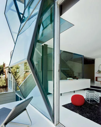 Vertical strips of field glazing'bonded to the frames on site'bring light and views to the guest room.