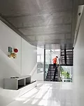 The transparency of the living spaces is accentuated by the balcony-like design of the living room and the perforated-steel stair.  