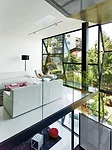 The transparency of the living spaces is accentuated by the balcony-like design of the living room and the perforated-steel stair. 