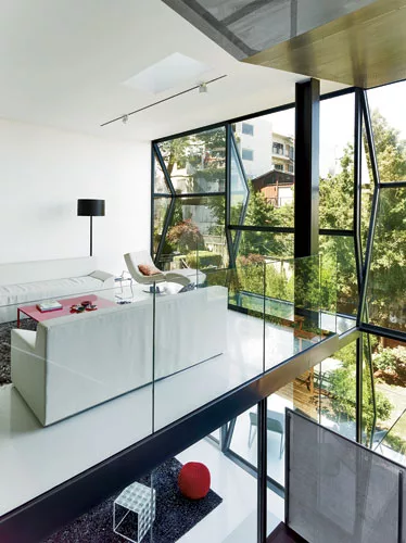 The transparency of the living spaces is accentuated by the balcony-like design of the living room and the perforated-steel stair.