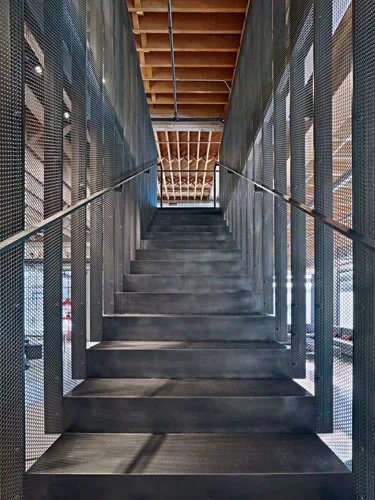 Viewed head on, the main stair's narrow steel risers look substantial, but in profile they almost disappear.