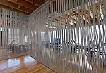 On the third floor the designers fashioned a breakout space from industrial rope and electrical conduit. They leavened the room's heavy look by suspending the curtain several inches above the floor.