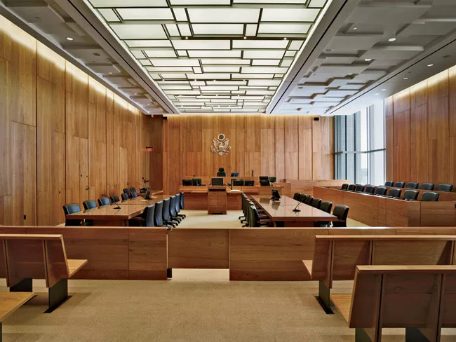 In each courtroom, the architects brought daylight in from two sides and paneled walls with pecan veneer. In most cases, they were able to extend some windows above the ceiling height to bring in extr