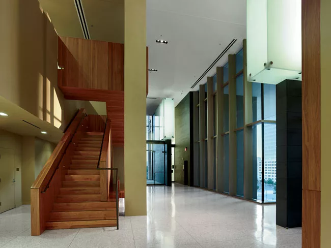 Internal stairs face outdoor terraces and connect double-height courtrooms with single-story spaces for jury deliberation and judges' offices.