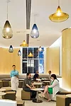 At the north end of the trattoria, Studio V designed a lounge where the avodire-wood-veneer panels and pendant lighting create a sfumato ambience at night.