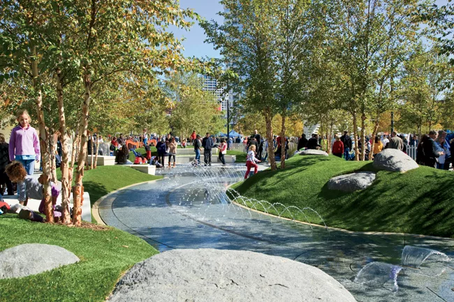 Children's park with raised geofoam mounds covered in artificial turf.