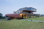 Nestled into the sloping site on an axis that will lead to other office buildings in the future, the 98,850-square-foot structure offers green roofs and a variety of outdoor spaces shaded by cantileve