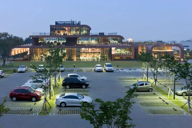From the south, visitors arriving in the evening can see how the 98,850-square-foot building arranges functions into open work areas and communal spaces such as those for dining and presentations.