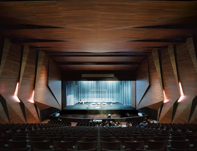 Oiled acacia wood panels lend a visual and acoustic richness to the concert hall. A cavity above the space accommodates lighting technicians as well as serving to draw smoke up and out of the space in