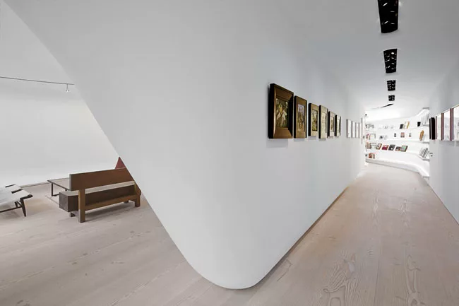 A suspended serpentine wall snakes along the length of the loft and touches down by the living area at the north end for stability. The ultrasmooth, hand-plastered surfaces and the slightly textured D