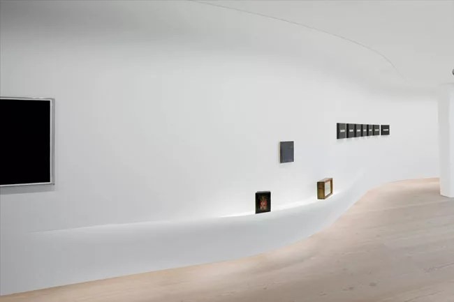 On the side of the suspended wall facing the gallery, halogen fixtures for the cove lighting and fluorescent lighting for its underside accentuate the ethereal quality of this setting.