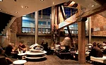 One floor below street level, the lounge has hanging, stainless steel fireplaces with openings on three sides. Two-tiered white 'hearths' prevent mingling crowds from bumping into these hot orbs, whil