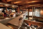 The ends of tables, made of Macassar ebony, poke through the mezzanine walls. Diners can glance over these partitions to catch the action below. 