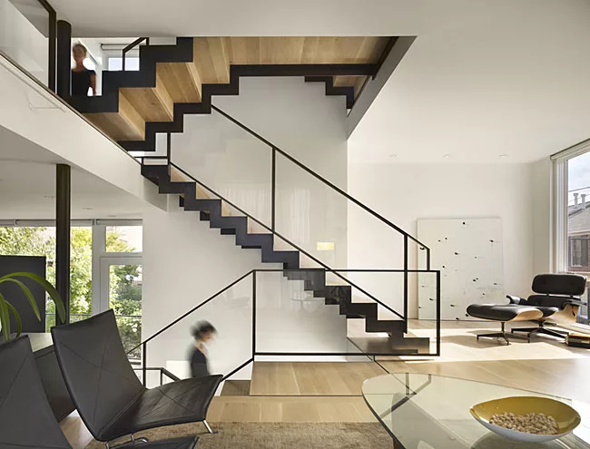 The interior of the Philadelphia townhouse spirals around a sparely designed open stair with patinated steel railings and bleached oak treads.
