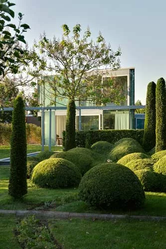 Since the angular glass house is located in a residential neighborhood, its owners decided to create a highly contoured garden adjoining it.  