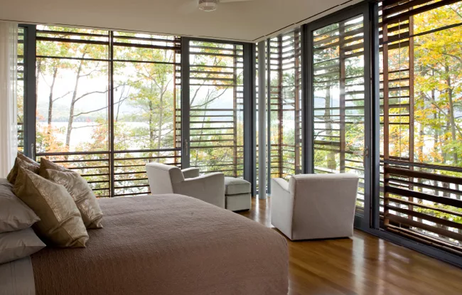 Slatted, Cambia wood screens shade all walls with views toward the lake in both buildings.