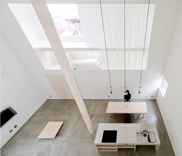 A staircase with treads of unpainted laurel wood leads from the ground level's concrete floor to the mezzanine levels above.