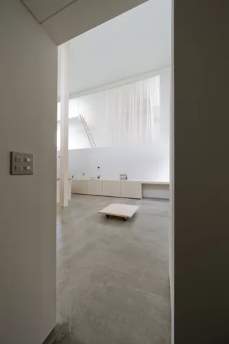 Catwalks and platforms accessible by ladders make the voids on the north and south sides of the house a sort of false exterior'bringing the focus to the central living zone where an 18.5-foot-high col