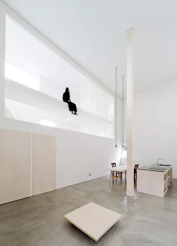 Catwalks and platforms accessible by ladders make the voids on the north and south sides of the house a sort of false exterior'bringing the focus to the central living zone where an 18.5-foot-high col