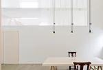 Light from the 'buffer zones' enters the central living area, which can be isolated by closing translucent white organdy curtains hanging on either of the space's long sides.