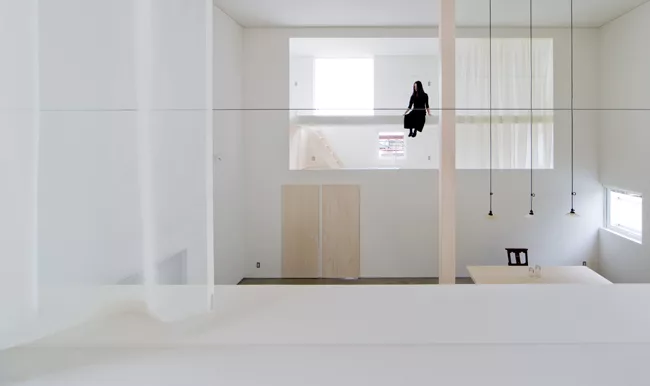 Catwalks and platforms accessible by ladders make the voids on the north and south sides of the house a sort of false exterior'bringing the focus to the central living zone where an 18.5-foot-high col