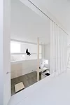Catwalks and platforms accessible by ladders make the voids on the north and south sides of the house a sort of false exterior'bringing the focus to the central living zone where an 18.5-foot-high col