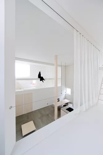 Catwalks and platforms accessible by ladders make the voids on the north and south sides of the house a sort of false exterior'bringing the focus to the central living zone where an 18.5-foot-high col