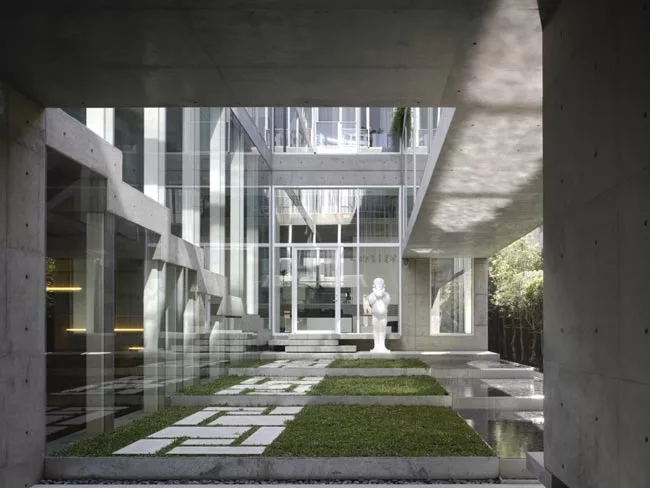 At the rear of the house, concrete decks and sectional cuts allow natural light to permeate the sitting area and an elevated dining space.