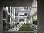 At the rear of the house, concrete decks and sectional cuts allow natural light to permeate the sitting area and an elevated dining space.