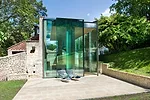 The fascia of the concrete roof is clad with soft gray aluminum to keep the color palette of the structure consistent when observed from the house's upper windows.  The pavilion's corner glass walls f