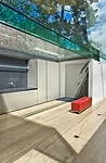The fascia of the concrete roof is clad with soft gray aluminum to keep the color palette of the structure consistent when observed from the house's upper windows.  The pavilion's corner glass walls f