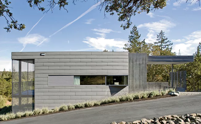 The architects chose a monochromatic palette, but experimented with texture. Zinc panels, concrete walls, and stained redwood screens unify the exterior.
