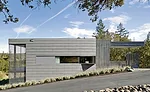 The architects chose a monochromatic palette, but experimented with texture. Zinc panels, concrete walls, and stained redwood screens unify the exterior.