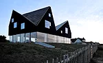 The jagged, timber-clad second story of the Dune House, on the east coast of England, contains bedrooms and bathrooms. 