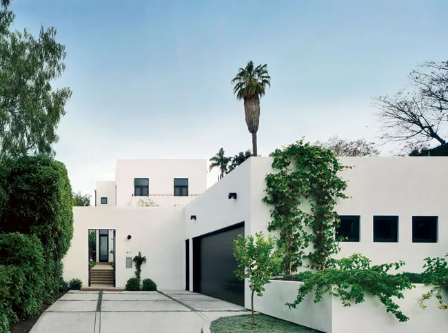 Architect James Gauer designed an elegant procession by separating the house from the street with a garage and garden.