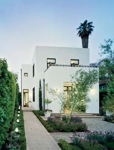 Architect James Gauer designed an elegant procession by separating the house from the street with a garage and garden.