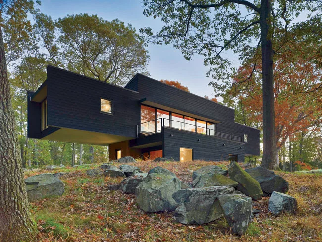 Large window walls maximize views and daylight for the main living spaces on the second floor.