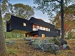 Large window walls maximize views and daylight for the main living spaces on the second floor.