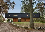 Clad in black-stained cedar, the upper story cantilevers 20 feet from each end.