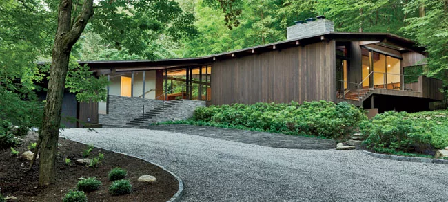 A long gravel driveway sweeps up to the front of the house.