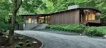 A long gravel driveway sweeps up to the front of the house.