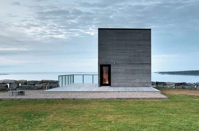 Visitors to the Cliff House approach an unfenestrated facade, punctuated by a single doorway.