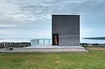 Visitors to the Cliff House approach an unfenestrated facade, punctuated by a single doorway.