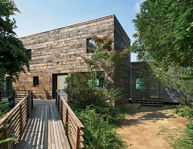 Located in a remote town of fewer than 1,000 residents on the North Fork of Long Island, the house is entered via a wood platform to the south.