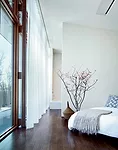 Floor-to-ceiling windows in the bedroom and living room open to sweeping views of the mountains.