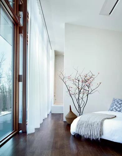 Floor-to-ceiling windows in the bedroom and living room open to sweeping views of the mountains.