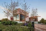 Nestled within a richly wooded site on a narrow strip of land, the 6,300-square-foot house comprises a series of cedar-clad boxes of varying heights with large, fully operable windows.