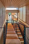  A dramatic stair leads to guest rooms on the lower level of the two-story bedroom wing.