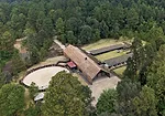 The 30,000-square-foot complex includes a freestanding main house flanked by stables and a riding ring.